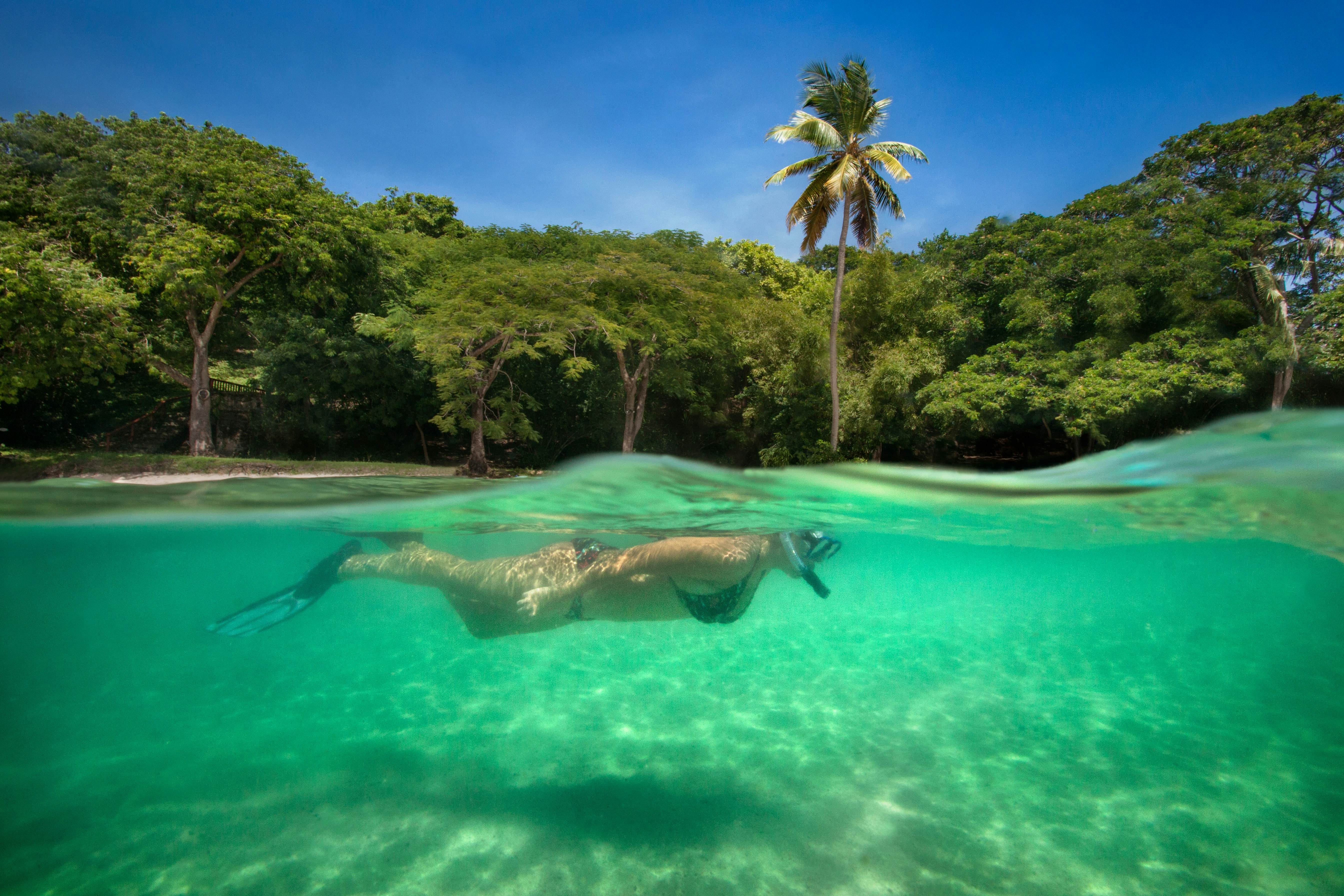 Split shot of female with snorkelling at Piegon Island in the Caribbean waters of Saint Lucia.